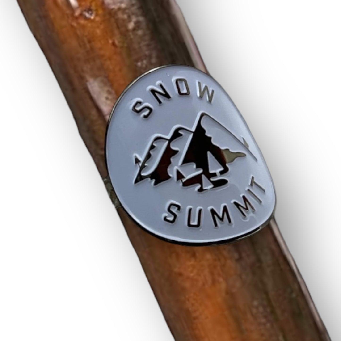 Metal medallion with two screws and a snow summit logo on it