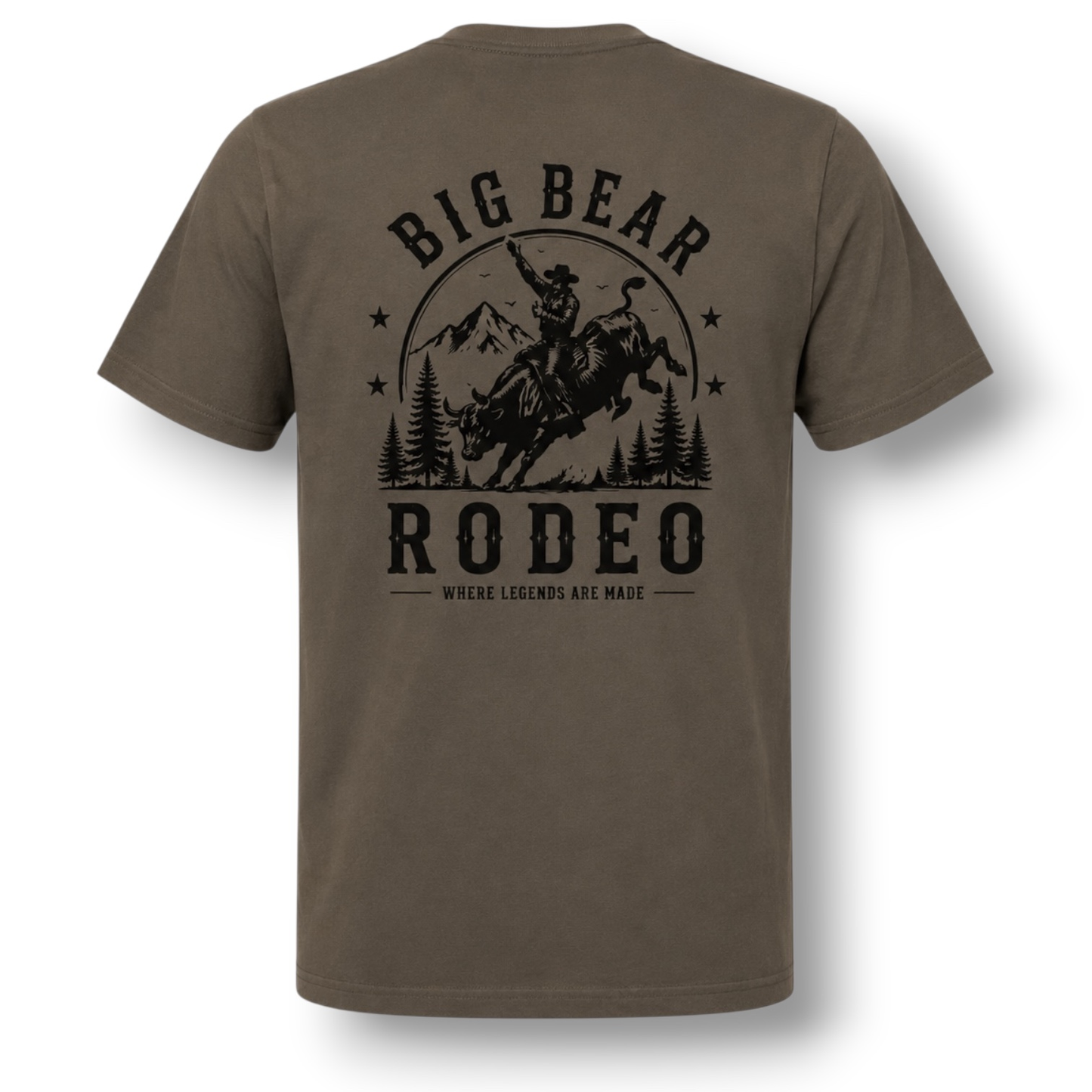 A dark color short-sleeve t-shirt with a black graphic print on the back featuring a cowboy riding a bucking bull in front of mountains and trees, with the text 'BIG BEAR RODEO' and 'WHERE LEGENDS ARE MADE'.