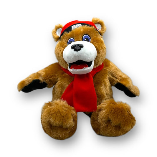 A plush brown bear toy with a red scarf and red with black brim beanie.