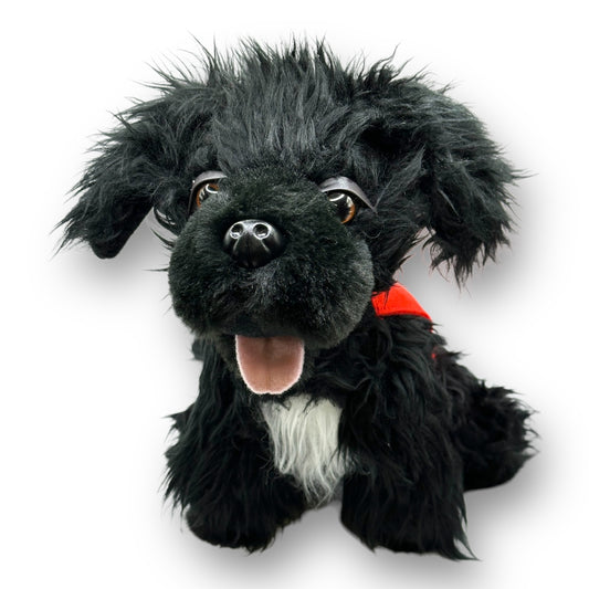 Plush black dog with red patrol vest and white fur spot on chest.
