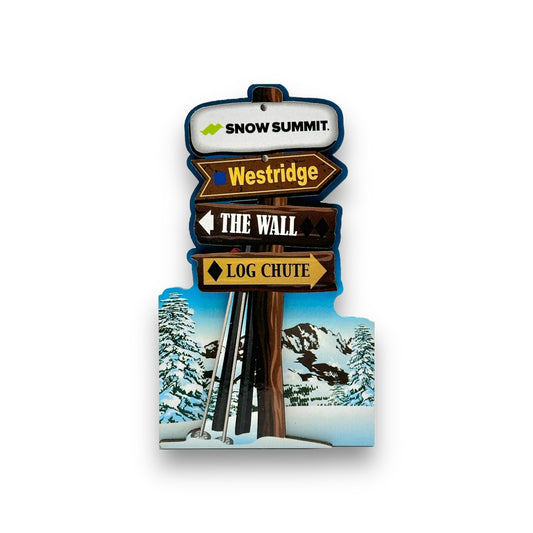 Wooden magnet with a snowy base with skis and ski poles leaned against wooden post that has Snow Summit logo at the top and three main winter trails beneath