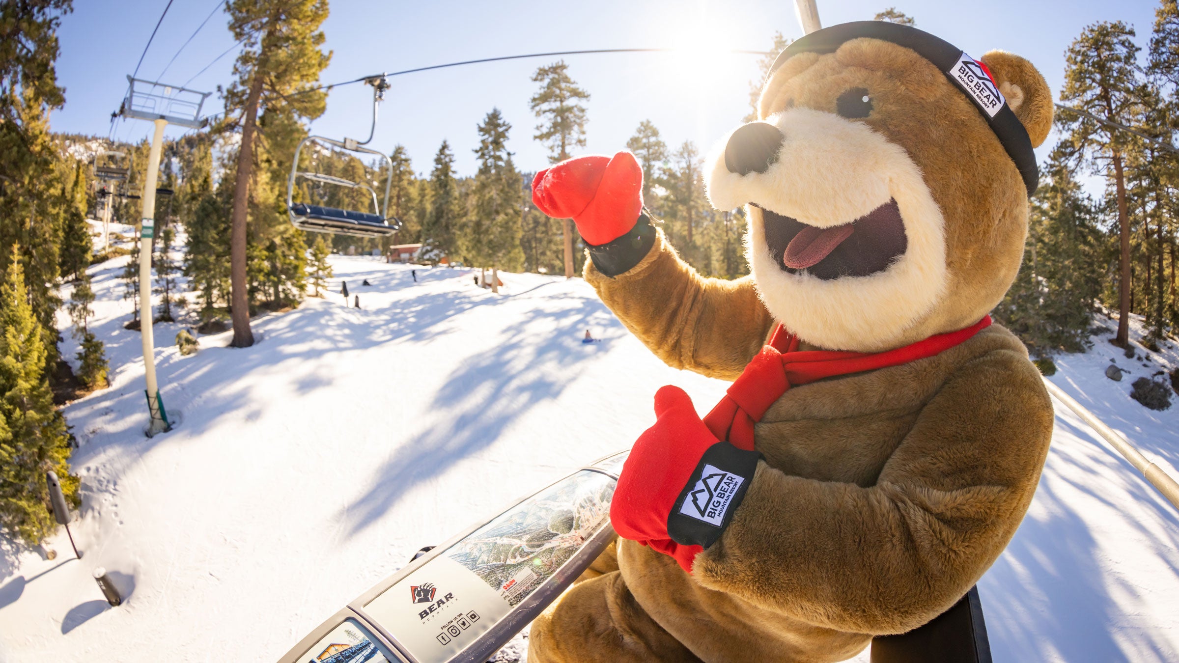 Big Bear Mountain Resort mascot, Biggie, on a chairlift at Bear Mountain