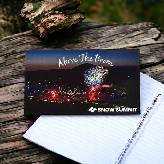 Above the Boom sticker of Big Bear Lake's annual 4th of July firework spectacular, Above the Boom, with an arial view of fireworks in the sky over the lake. On the bottom right corner, white Snow Summit logo.