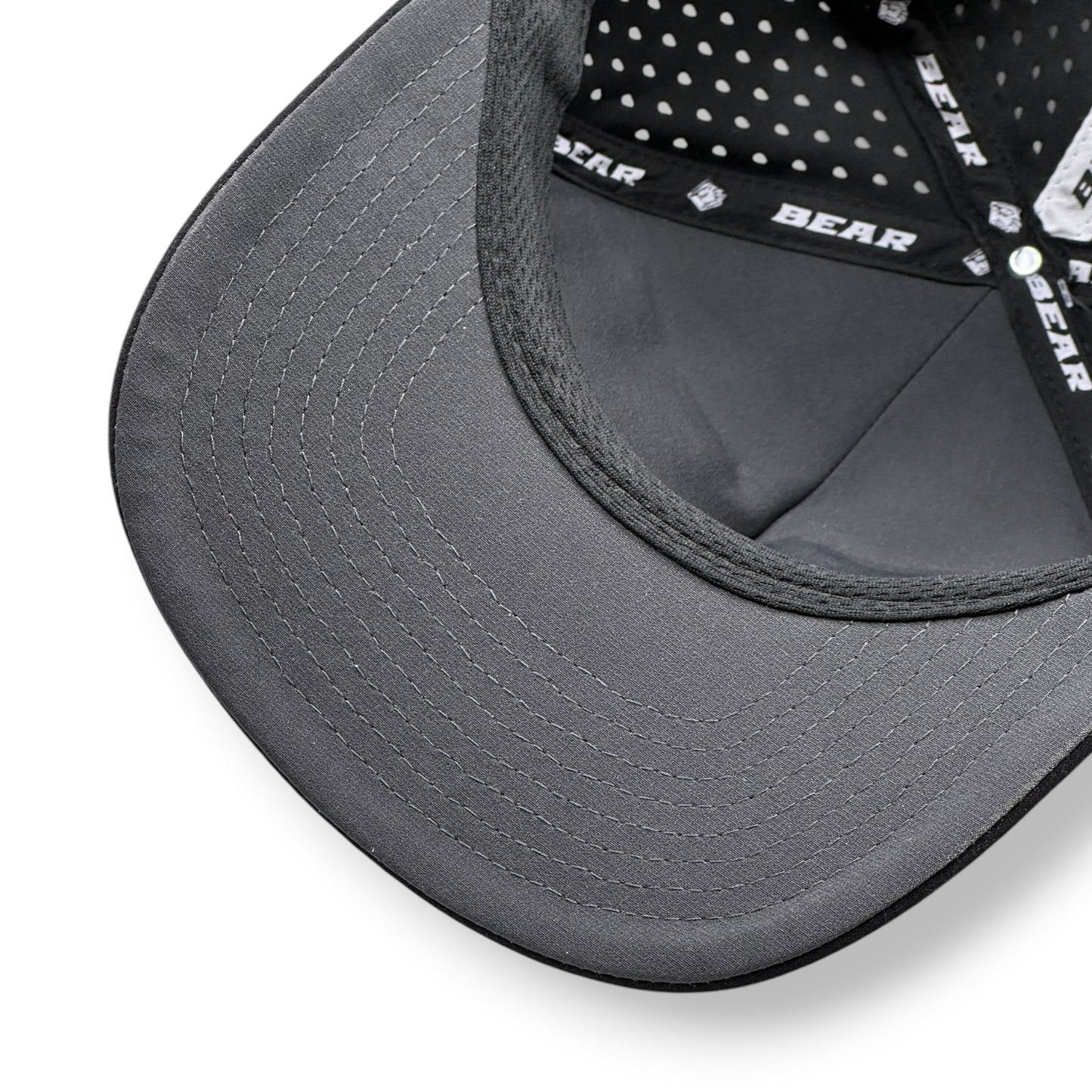 Close-up of a gray cap with mesh back and visible Bear branding on inside of hat.
