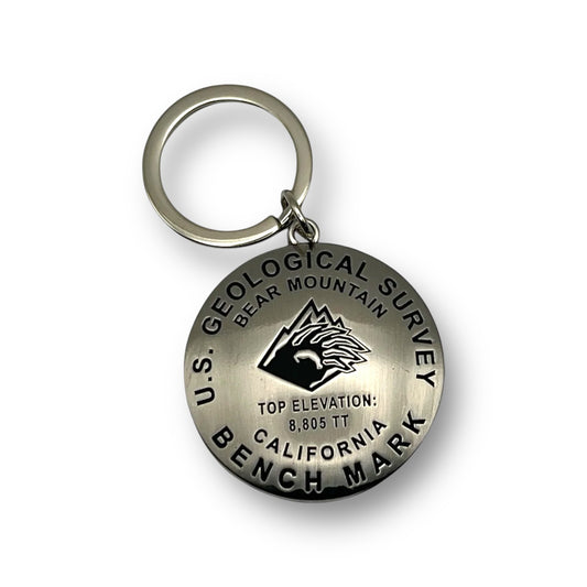 Silver keychange that has a bear mountain logo on it and with Geological Survey Bench Mark/Elevation