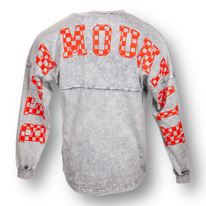 Backside of an oversized mineral wash crew neck long sleeve t-shirt with Bear Mountain in red checker letters on the back, from arm sleeve to arm sleeve.
