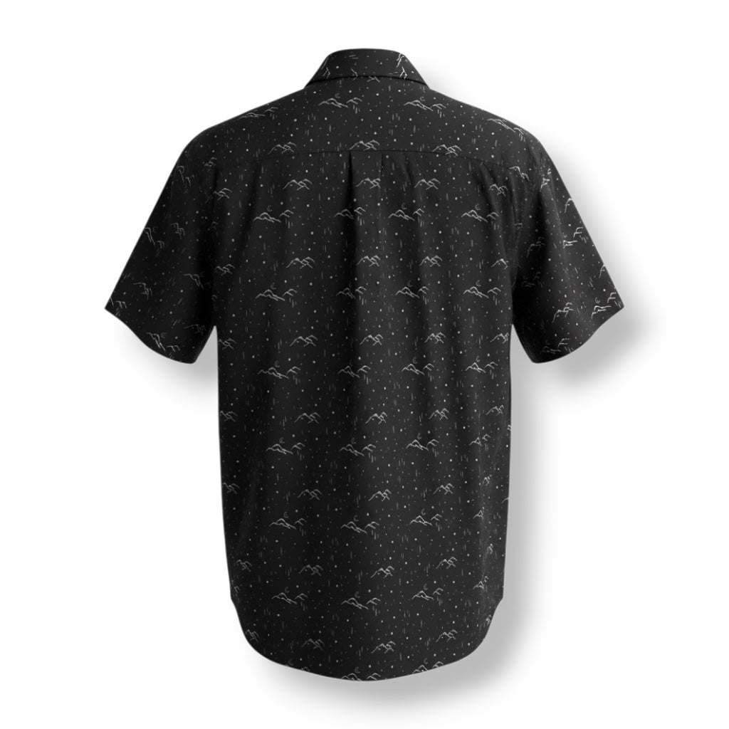 Backside of a black short sleeve button up shirt with mountain and moon design.