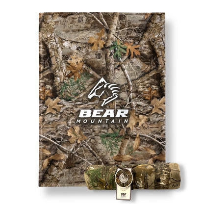 Camouflage woods patterned sweatshirt blanket with Bear Mountain logo in white.