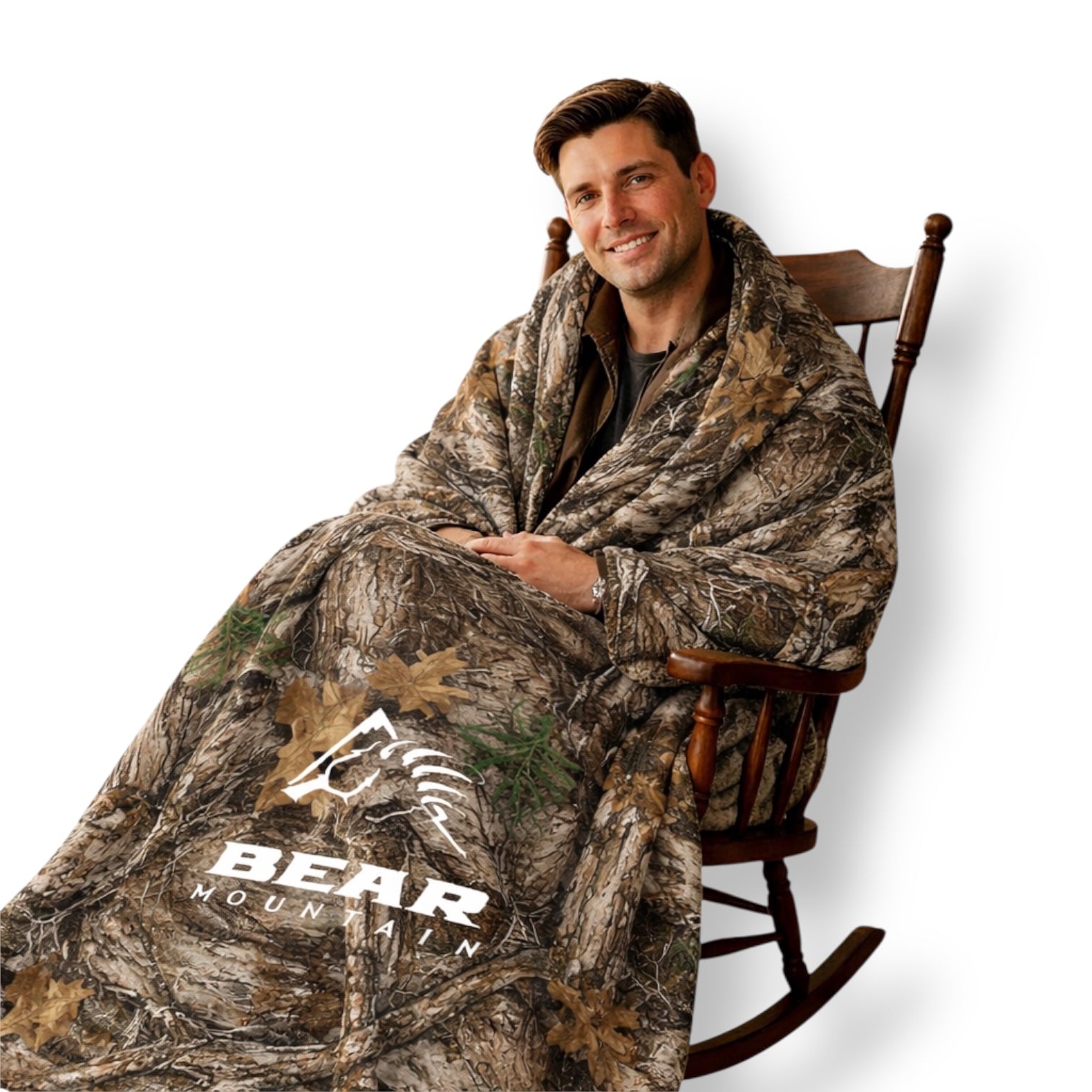 Adult with dark hair sitting in a rocking chair wearing a camouflage woods blanket with Bear Mountain branding.