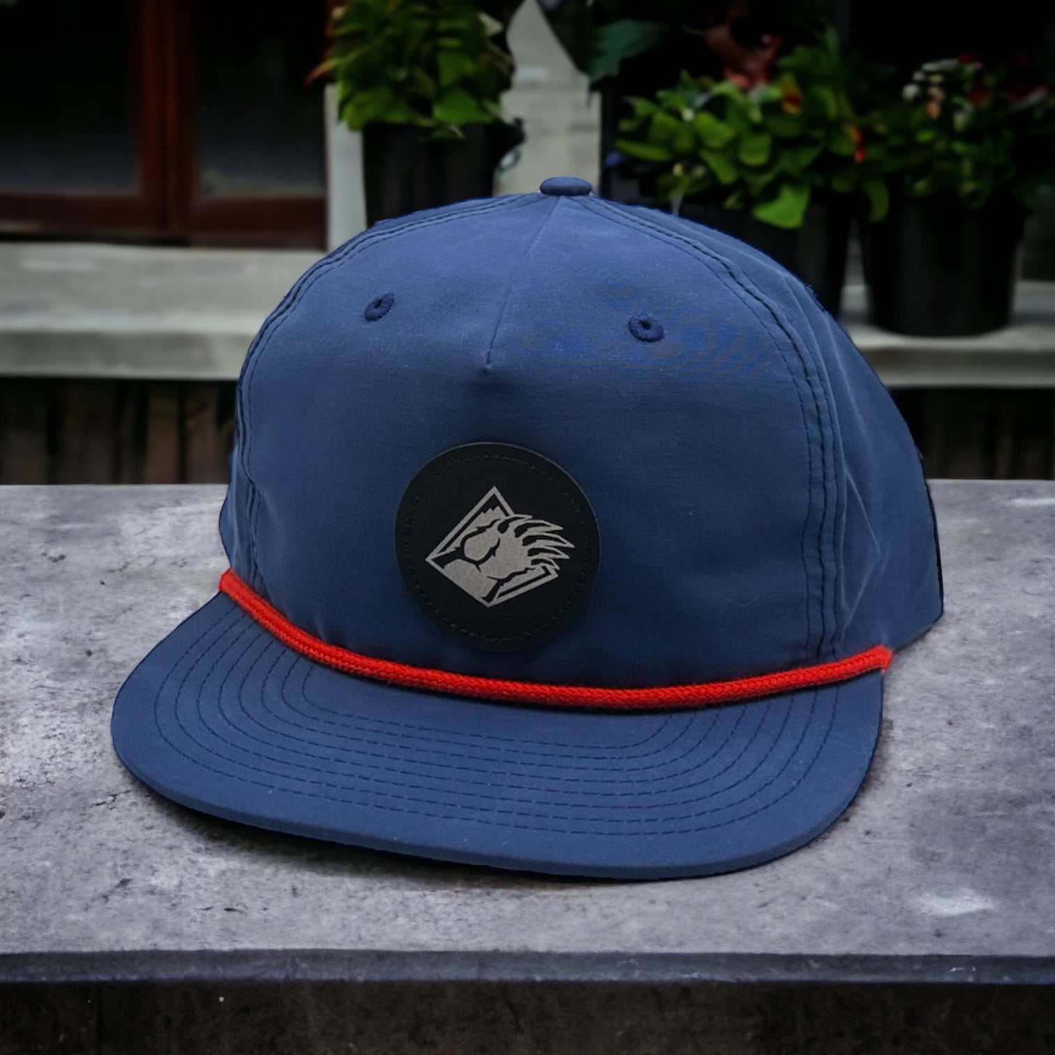 Blue hat with Bear claw logo and red rope on mid crown.