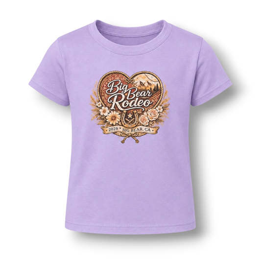 A lilac color short-sleeve t-shirt featuring a large 'Big Bear Rodeo' graphic on the front with a heart, floral elements, and a horseshoe.