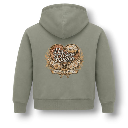 An olive green hooded sweatshirt shown from the back, featuring a large vintage-style 'Big Bear Rodeo 2026 at Bear, CA' graphic printed in the center.