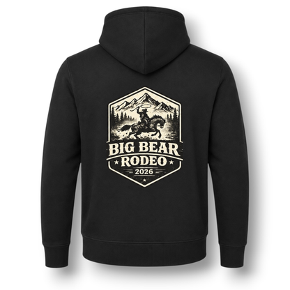 The back of a black hoodie, featuring a large white colored graphic print that reads 'BIG BEAR RODEO 2026' with an illustration of a cowboy on a horse in front of mountains.