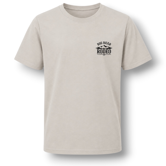 A light color crewneck t-shirt with a small black graphic on the left chest reading 'BIG BEAR RODEO', displayed flat against a white background.