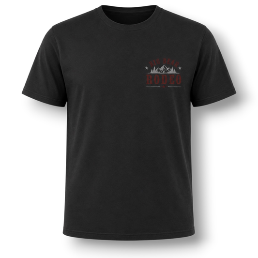 A black short-sleeve crewneck t-shirt with a small graphic on the left chest featuring the text 'Big Bear Rodeo' in red and grey with a mountain silhouette, displayed on a solid white background.