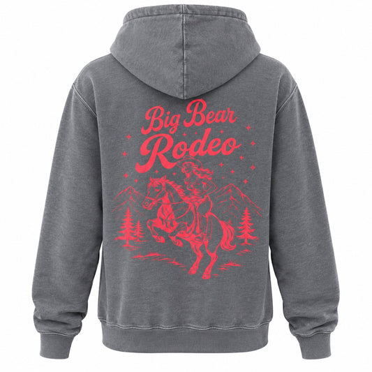 A dark gray hooded sweatshirt shown from the back, featuring a large red graphic print of a cowboy riding a bucking horse with the words 'Big Bear Rodeo' and small mountain and tree silhouettes.