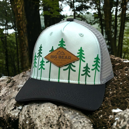 Mesh trucker had with a leather logo and green trees