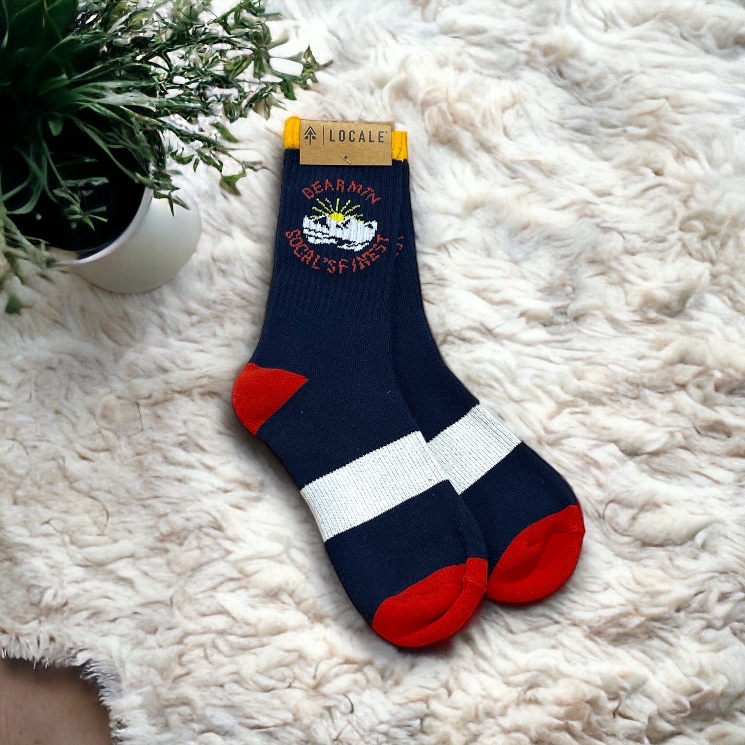 Red, white, & blue Locale Bear Mountain sock with mountain and sun design.