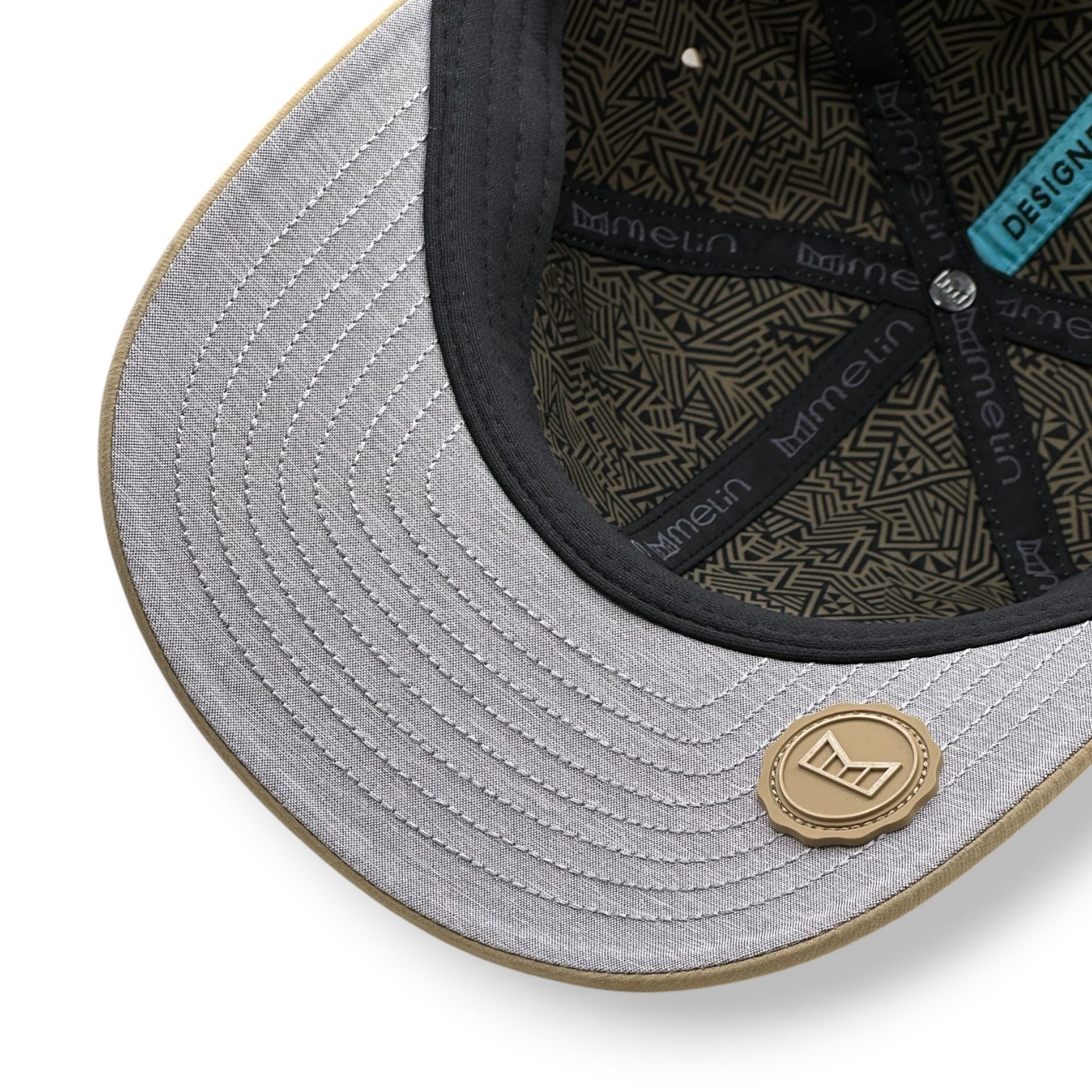 Close-up of a gray cap with black interior and Melin brand logo.