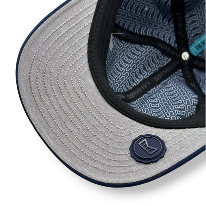 Close-up of a gray under bill of a navy cap with Melin brand logo.