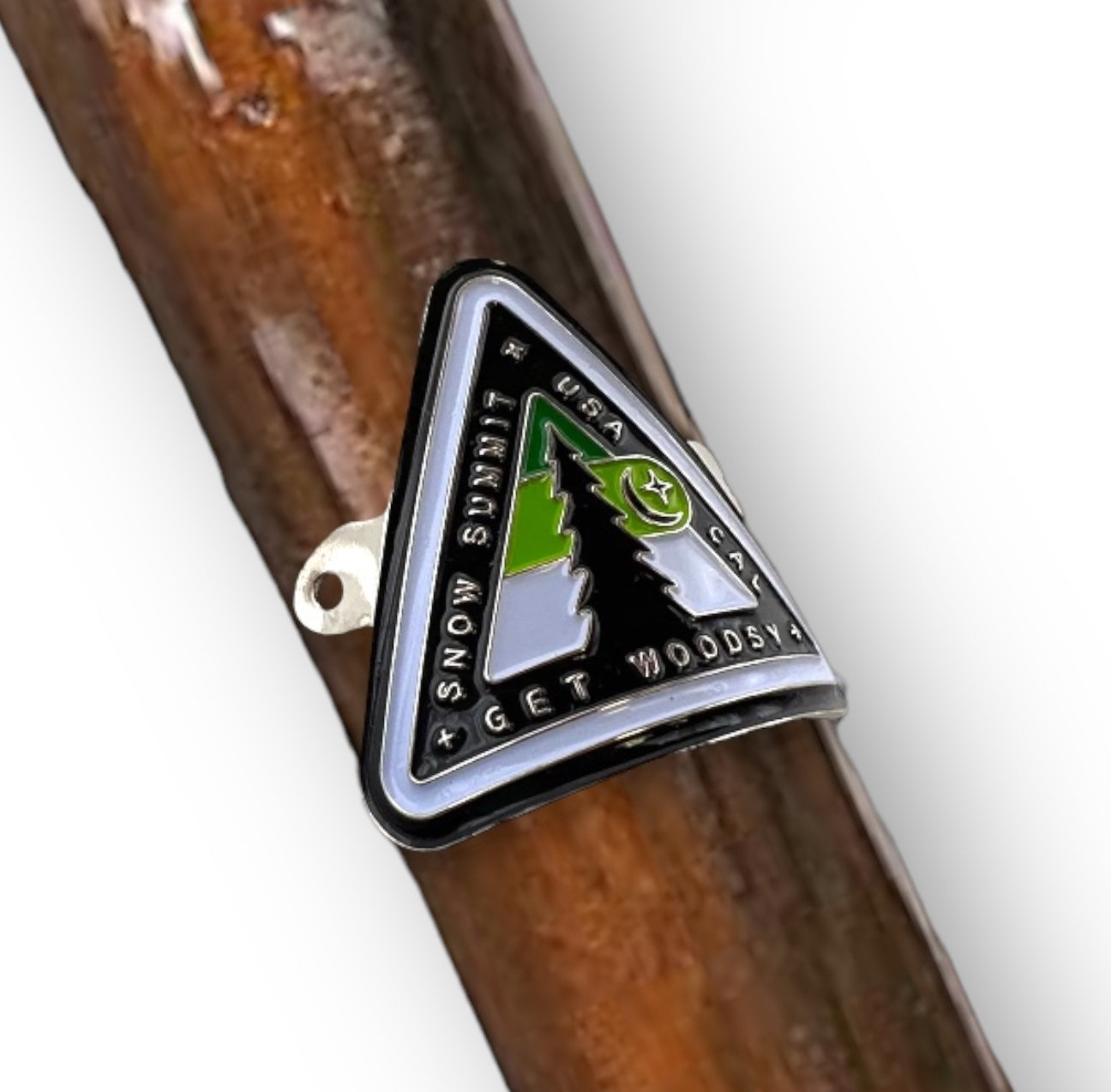 Metal medallion with two screws and a woodsy themed logo on it