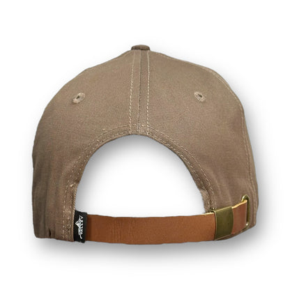 Beige brown hat with a Snow Valley brand logo on the back next to the leather adjustable strap.