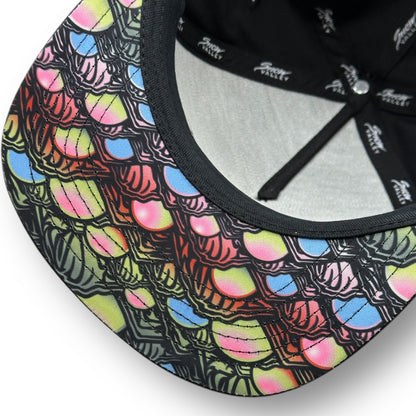 The underside of a Snow Valley hat with dark color and colorful fish scale pattern under the brim.