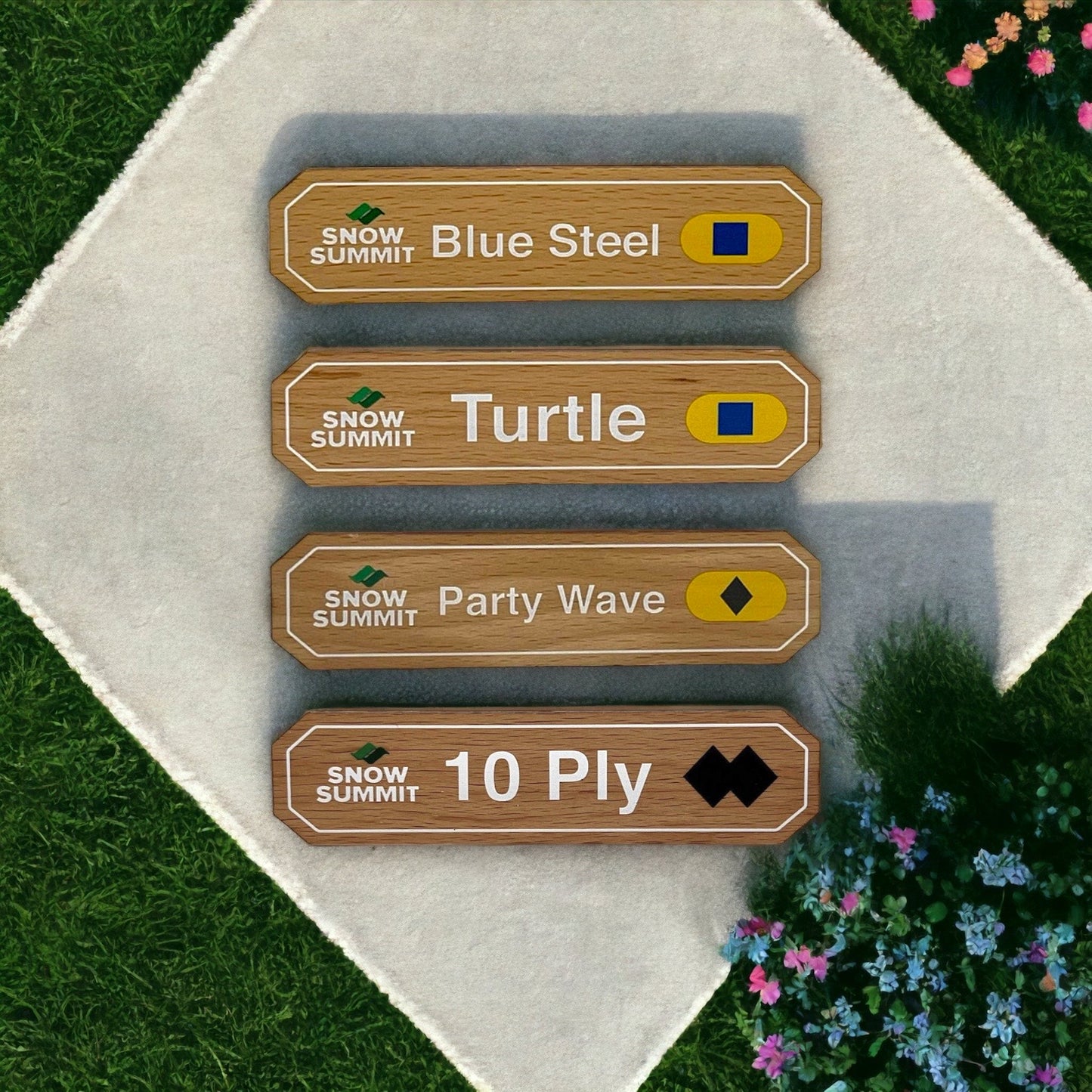 Wooden magnets with a Snow Summit logo on the left and trail signs for: Blue Steel, Turtle, Party Wave, and 10 Ply copy on it with difficulty legend rating