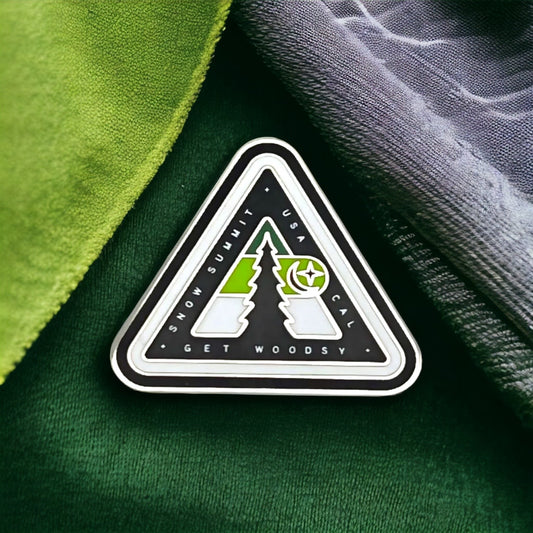 Woodsy logo on a pin with green coloring