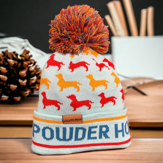 Teal beanie with Red and yellow dogs with the word Powder Hound in blue