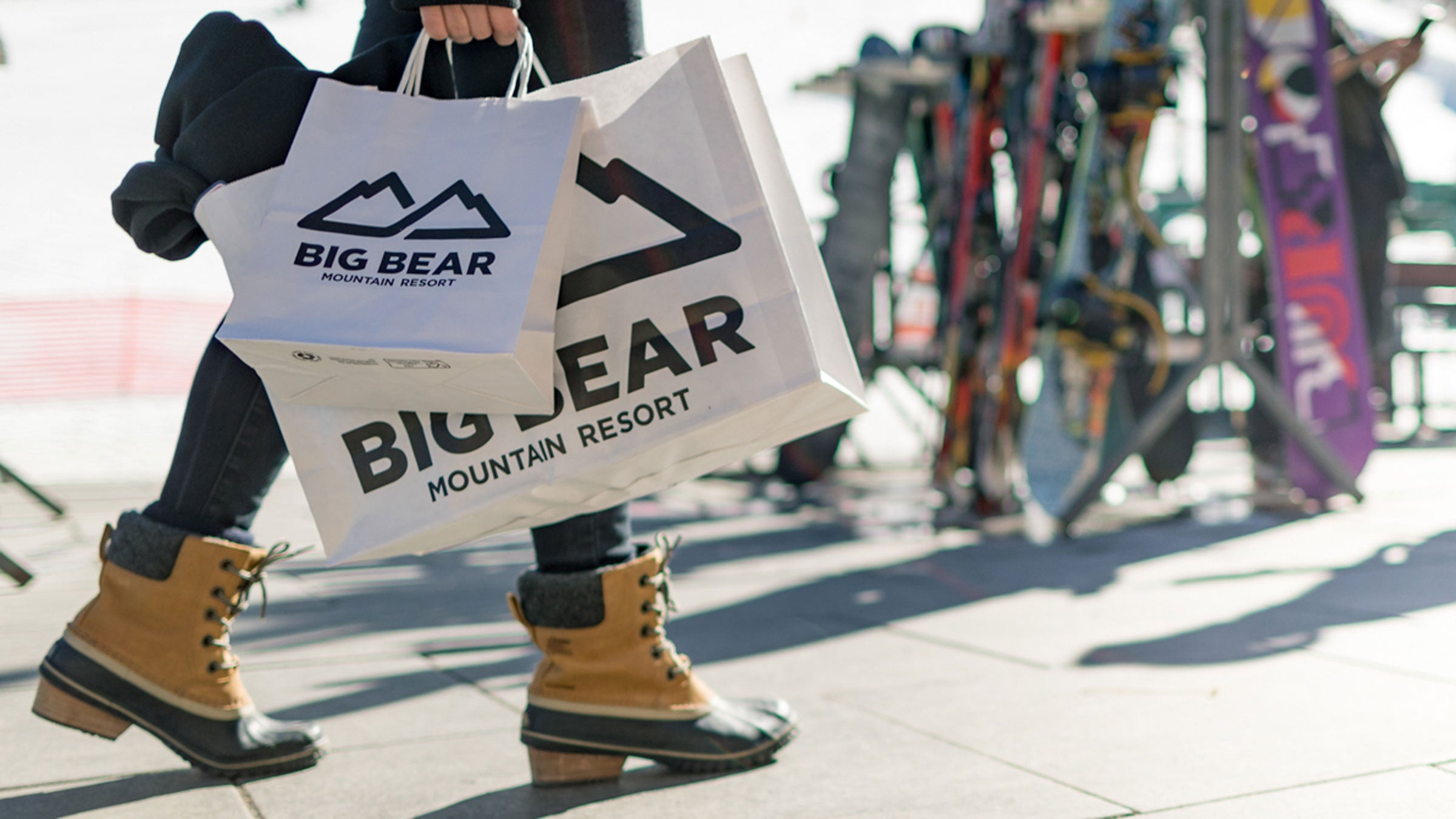 Adult holding Big Bear Mountain Resort shopping bags at Bear Mountain